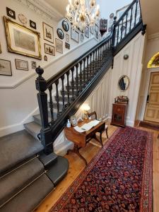 a staircase in a house with a table and a rug at Barony House 5 Star Boutique BK Direct in Edinburgh