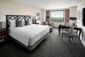 a hotel room with a large white bed and a desk at The Ritz Carlton, Pentagon City in Arlington