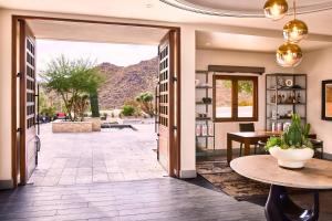 un couloir avec une porte s'ouvrant sur une terrasse avec une table dans l'établissement ADERO Scottsdale Resort, Autograph Collection, à Scottsdale