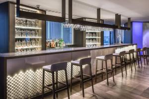 a bar with stools in a room with a window at AC Hotel Gran Canaria by Marriott in Las Palmas de Gran Canaria