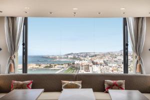 a room with a couch and a large window at AC Hotel Gran Canaria by Marriott in Las Palmas de Gran Canaria