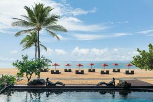 a group of people doing yoga on the beach at The St. Regis Bali Resort in Nusa Dua
