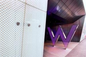 a purple sign that says w on a wall at W London in London