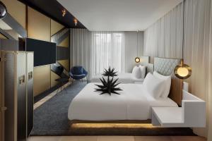 a hotel room with a large white bed and a desk at W London in London