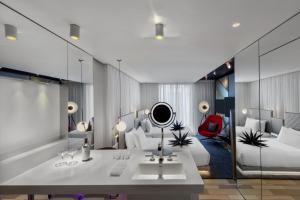 a hotel room with two beds and a mirror at W London in London