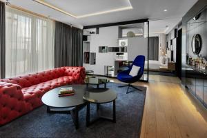 ein Wohnzimmer mit einem roten Sofa und einem blauen Stuhl in der Unterkunft W London in London