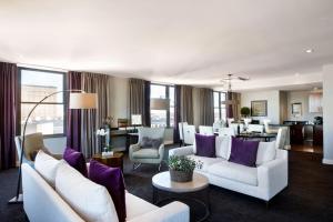 a living room with white furniture and purple pillows at Ambassador Hotel Wichita, Autograph Collection in Wichita