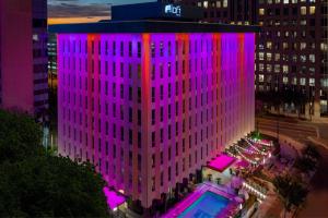 a tall building with a pool in front of it at Aloft by Marriott Orlando Downtown in Orlando