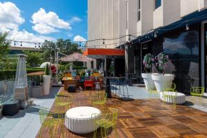 un patio avec des chaises et des tables jaunes et un bâtiment dans l'établissement Aloft Orlando Downtown, à Orlando