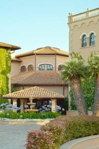 ein großes Haus mit Palmen davor in der Unterkunft The St. Regis Mardavall Mallorca Resort in Portals Nous