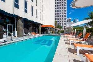 a swimming pool with lounge chairs and a building at Aloft Orlando Downtown in Orlando