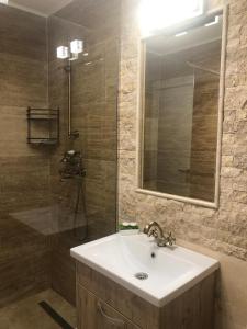 a bathroom with a sink and a shower with a mirror at Apartament Nicolle in Poiana Brasov