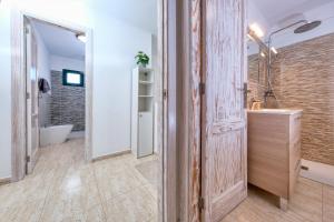 a bathroom with a wooden door and a sink at Casa Gemma-quiet and relaxing place in Costa Teguise