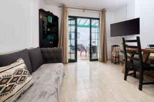 een woonkamer met een bank en een tafel bij Casa Gemma-quiet and relaxing place in Costa Teguise
