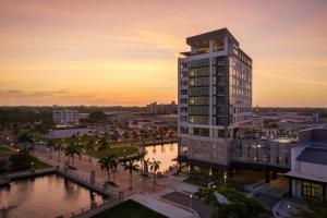 a tall building with a sunset in the background at Luminary Hotel & Co., Autograph Collection in Fort Myers