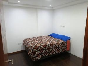 Un dormitorio con una cama con una almohada azul. en Cómodo conjunto residencial en la cuidad de Cuenca, en Cuenca