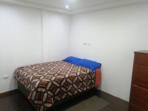 Un dormitorio con una cama con una almohada azul. en Cómodo conjunto residencial en la cuidad de Cuenca, en Cuenca