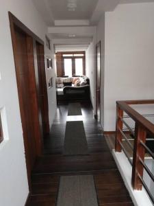 pasillo que conduce a una sala de estar con sofá en Cómodo conjunto residencial en la cuidad de Cuenca, en Cuenca