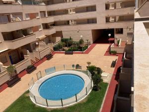 - une vue sur la piscine située dans un bâtiment dans l'établissement Coqueto y acogedor apartamento con piscina, à Roquetas de Mar