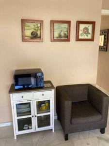- un salon avec une chaise et une télévision dans l'établissement Coqueto y acogedor apartamento con piscina, à Roquetas de Mar