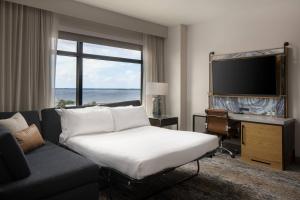 a living room with a couch and a large window at Luminary Hotel & Co., Autograph Collection in Fort Myers