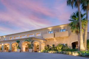 un gran edificio blanco con palmeras delante en Hacienda Son Antem Golf Resort, Autograph Collection en Llucmajor