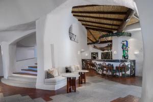 ポルト・チェルボにあるHotel Cala di Volpe, a Luxury Collection Hotel, Costa Smeraldaの白い壁と木製の天井のリビングルーム