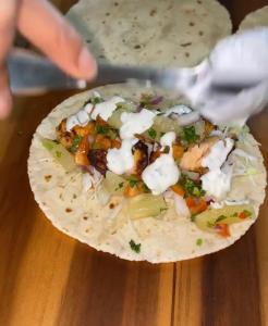 a person is holding a tortilla with vegetables on it at Suite Subzero in Lagos