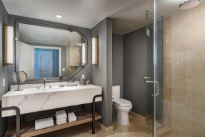 a bathroom with a sink and a toilet and a mirror at JW Marriott Orlando Grande Lakes in Orlando