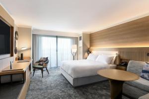 a hotel room with a bed and a desk and a tv at JW Marriott Orlando Grande Lakes in Orlando
