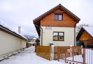 a house with a wooden fence in the snow at SIKY-LIPTOV in Liptovský Ján +5 photos