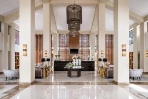 een lobby met banken en een tafel met bloemen bij Sheraton Cascais Resort - Hotel & Residences in Cascais