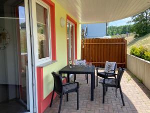 einen Tisch und Stühle auf der Terrasse eines Hauses in der Unterkunft Ferienwohnung "Seeperle" Marina Mücheln Geiseltalsee in Mücheln