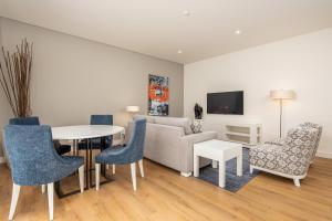 a living room with a couch and a table and chairs at Sheraton Cascais Resort - Hotel & Residences in Cascais