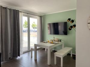 ein Esszimmer mit einem weißen Tisch und einem Fenster in der Unterkunft Ferienwohnung "Seeperle" Marina Mücheln Geiseltalsee in Mücheln