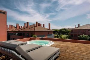 a patio with chairs and a swimming pool on a roof at Sheraton Cascais Resort - Hotel & Residences in Cascais