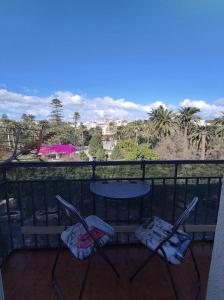 two chairs and a table on a balcony with a view at Apartamento céntrico con vistas in Melilla