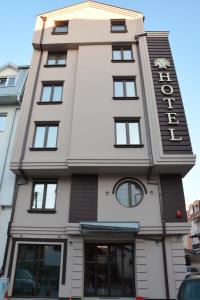un edificio blanco alto con un reloj en él en Hotel Vlaho, en Skopje