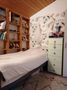 ein Schlafzimmer mit einem Bett und einer Kommode in der Unterkunft maison bois in Ruaudin