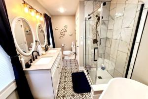 a bathroom with two sinks and a shower and a toilet at Luxury Listing - 92 Walkable Score Downtown Kzoo in Kalamazoo