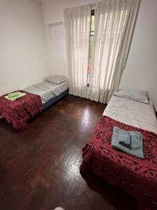 Barraquero的住宿－Vivi Mendoza，一间卧室设有两张床和窗户。