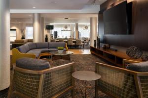 a living room with a couch and a flat screen tv at Courtyard by Marriott Scottsdale Salt River in Scottsdale
