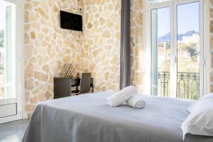 a white bed in a room with a window at Hotel De Belgique à Menton in Menton