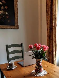 ArmailléにあるLes Hirondelles B&Bの木製テーブルの上にピンクの花瓶