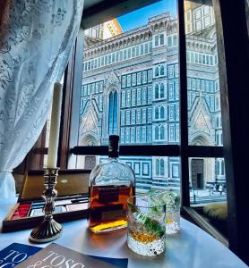 butelka whisky na stole przed oknem w obiekcie La Mandorla studio apartment in Piazza del Duomo we Florencji