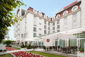 an exterior view of a hotel with tables and umbrellas at Sheraton Sopot Hotel in Sopot