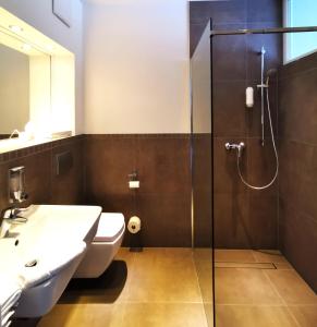 a bathroom with a shower and a toilet and a sink at Hotel Gutsmühle in Obernburg am Main
