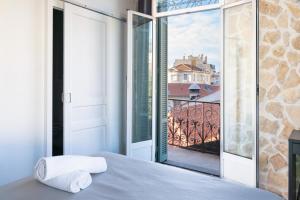 a bedroom with a bed and a view of a balcony at Hotel De Belgique à Menton in Menton