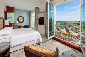 a hotel room with a bed and a balcony at Sheraton Sopot Hotel in Sopot