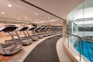 a gym with rows of treadmills and a swimming pool at JW Marriott Hotel Seoul in Seoul